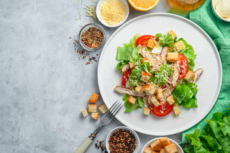 Salad with vegetables and chicken breast on a gray background. Traditional Caesar salad. The concept of healthy nutrition.の写真素材