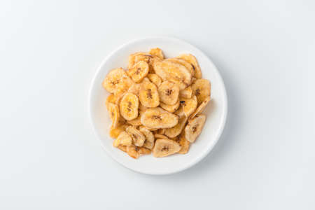 A plate of banana chips on a light background. Top view. The concept of natural, healthy sweets.の写真素材