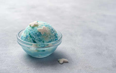 Berry ice cream in a transparent bowl on a gray background. Side view copy space.
