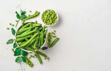 Pea pods and open peas on a gray background with space for copying. Natural, healthy food.の写真素材