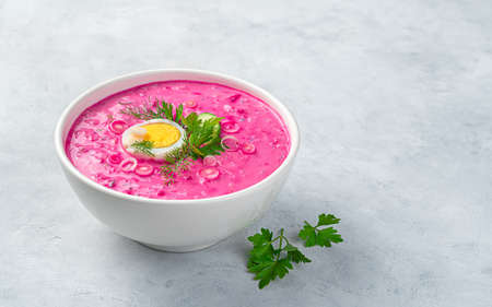 Traditional Lithuanian beetroot soup with cucumber, potatoes, beetroot, fresh herbs and kefir on a gray background. Healthy, vegetarian food.の写真素材