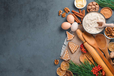 Ingredients, kitchen tools and ginger cookies on a dark background. Top view, copy space. Christmas background.の写真素材
