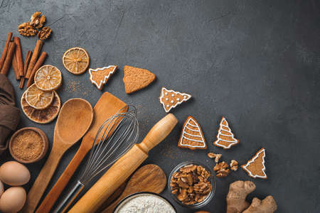 Festive culinary background. Ingredients, ginger cookies and cooking utensils on a brown background. Copy spaceの写真素材