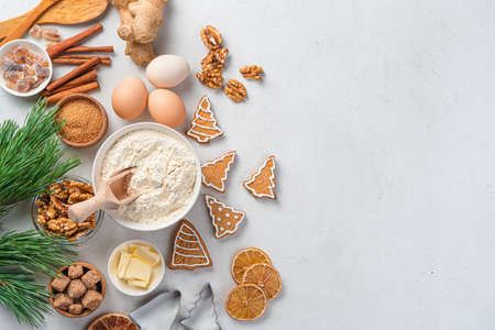 Christmas cooking background with baking ingredients and ginger cookies on a gray background. Happy...