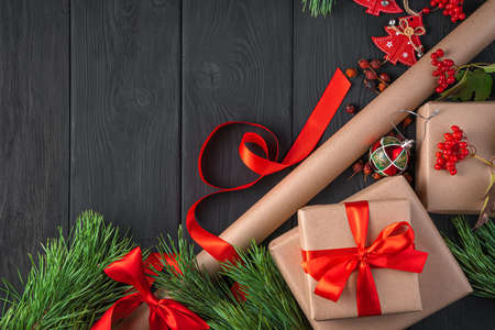 Gifts and wrapping paper on a dark background. The concept of Christmas and New Year. Top view, copy space.の写真素材