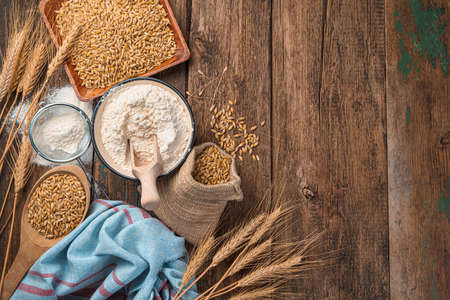 Wheat and wheat flour on a wooden background with space to copy. Top view, horizontal.の写真素材