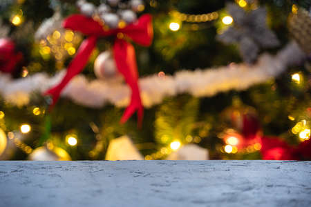 Christmas background with a table on the background of a decorated Christmas tree. Unfocused. Side view.の写真素材