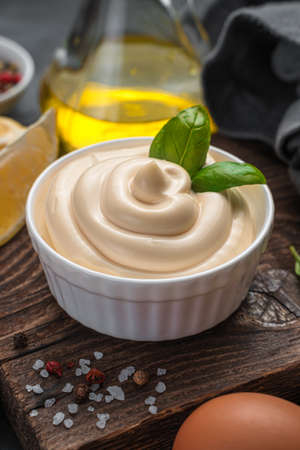 Mayonnaise with fresh basil close-up. Side view, vertical. Homemade mayonnaise.の写真素材