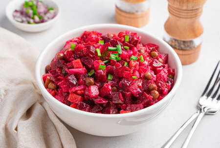 Traditional Russian salad vinaigrette with beets, potatoes, carrots and sauerkraut on a gray one. Side view, close up.の写真素材