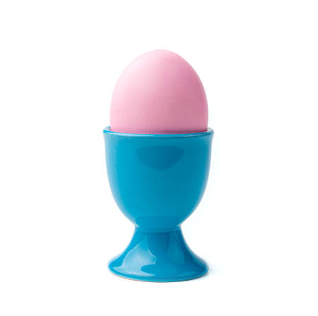 A pink Easter egg on a stand is isolated on a white background. Side view, close-up.の写真素材