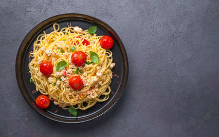 Spaghetti with oven-baked feta cheese, tomatoes and herbs. Fetapasta. Top view, copy space.の写真素材