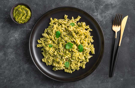 A portion of pasta with basil pesto sauce on a dark background. Top view, horizontal.の写真素材