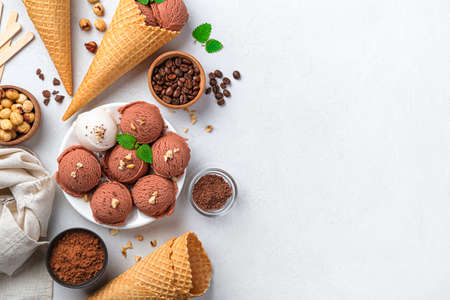Balls of chocolate and cream ice cream on a gray background. Top view, copy space.