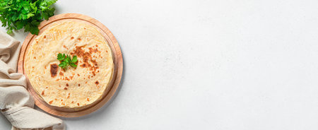 Traditional Indian flatbreads with fresh herbs on a gray background. Top view, copy space