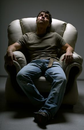 relaxed young man in white chairの写真素材
