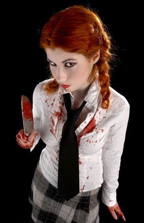 angry schoolgirl with bloody knife over blackの写真素材