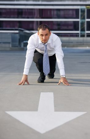 arrow pointer and handsome businessman ready for raceの写真素材