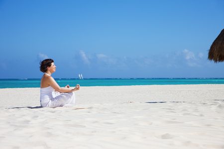 meditation of happy woman in lotus pose on the beachの写真素材