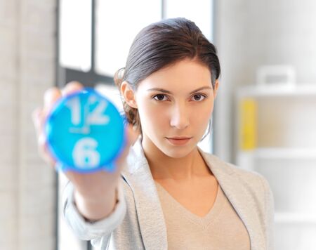 bright picture of attractive businesswoman with clockの写真素材