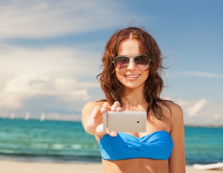 picture of happy woman with phone on the beach の写真素材