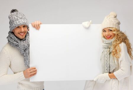picture of family couple in a winter clothes holding blank boardの写真素材