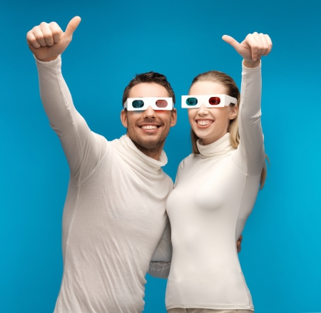 man and woman with 3d glasses showing thumbs upの写真素材
