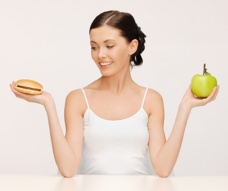 picture of beautiful woman with hamburger and appleの写真素材