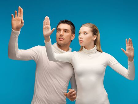 picture of man and woman working with something imaginary.の写真素材