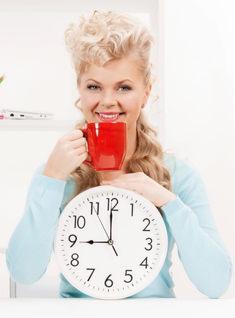 picture of attractive businesswoman with clock and red cupの写真素材