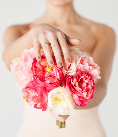 close up of bride with bouquet of flowers and wedding ring の写真素材