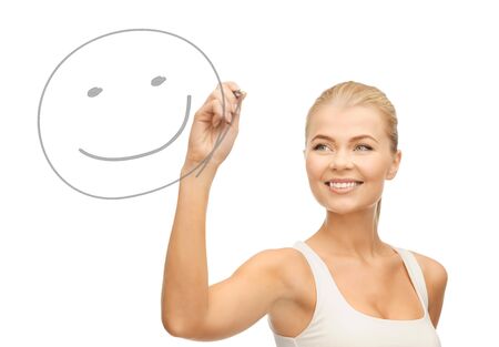 smiling woman in white shirt drawing happy smile on glassの写真素材