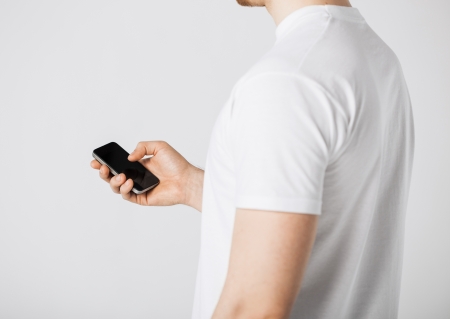 close up of man with smartphone typing somethingの写真素材