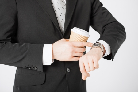 close up of man with take away coffee looking at wristwatchの写真素材