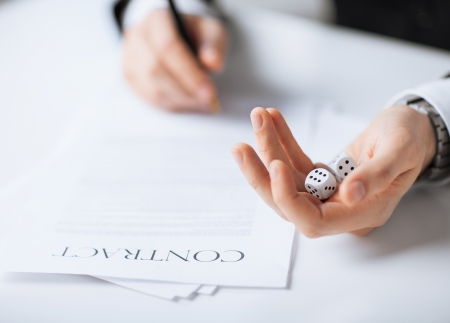 picture of man hands with gambling dices signing contractの写真素材