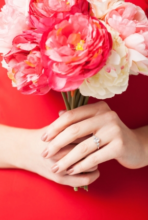 woman hands with bouquet of flowers and wedding ring の写真素材