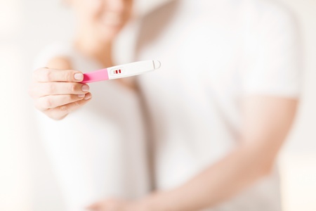 close up of woman and man hands with pregnancy testの写真素材