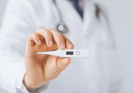 bright close up of male doctor with thermometerの写真素材