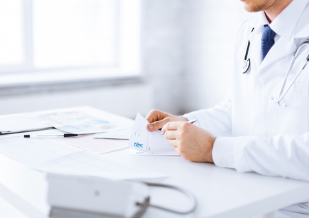 close up of male doctor writing prescription paperの写真素材