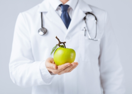 close up of male doctor with green appleの写真素材