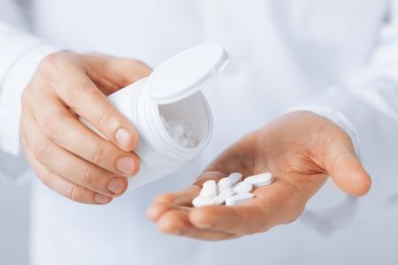 picture of doctor hands holding white pack and pillsの写真素材