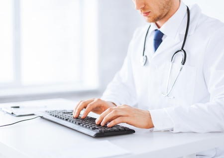 close up of male doctor typing  on the keyboardの写真素材