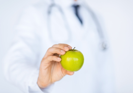 close up of male doctor with green appleの写真素材