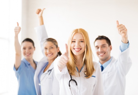 attractive female doctor with group of doctors showing thumbs upの写真素材
