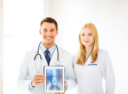 bright picture of two doctors showing x-ray on tablet pc