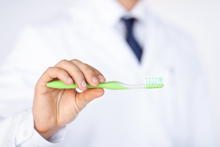 close up of male dentist or stomatologist holding toothbrush..の写真素材