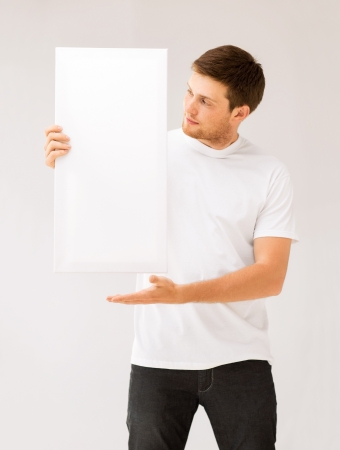 picture of young man holding white blank boardの写真素材