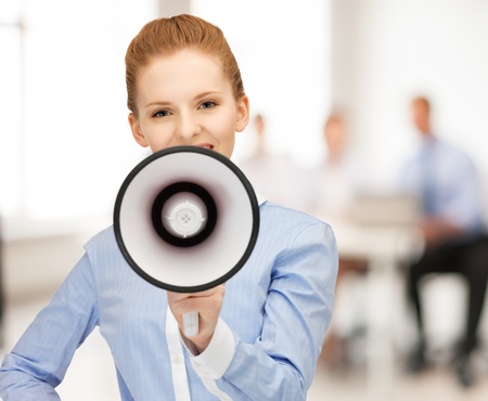 close up of friendly businesswoman with megaphone in officeの写真素材