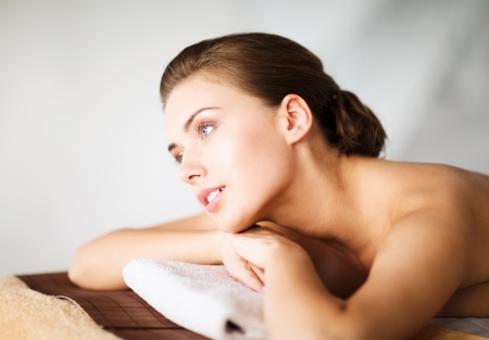 beauty and spa concept - woman in spa salon lying on the massage deskの写真素材
