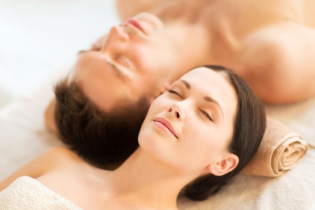 picture of couple in spa salon lying on the massage desksの写真素材