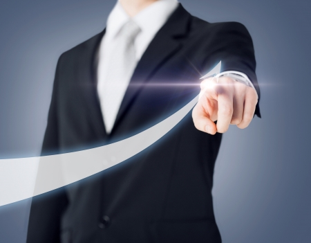 business concept - businessman hand showing raising arrow on virtual screenの写真素材